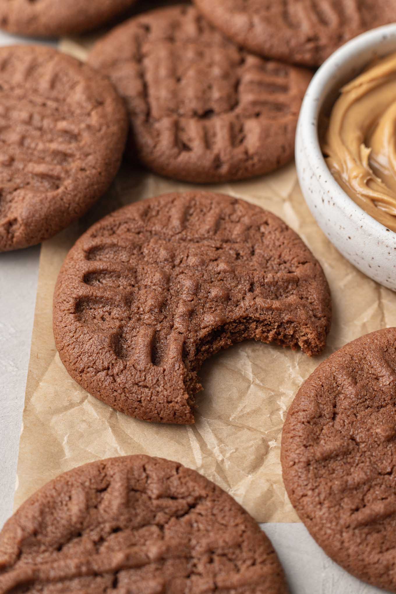 Una vista de cerca de una galleta de chocolate con mantequilla de maní a la que le falta un bocado. 