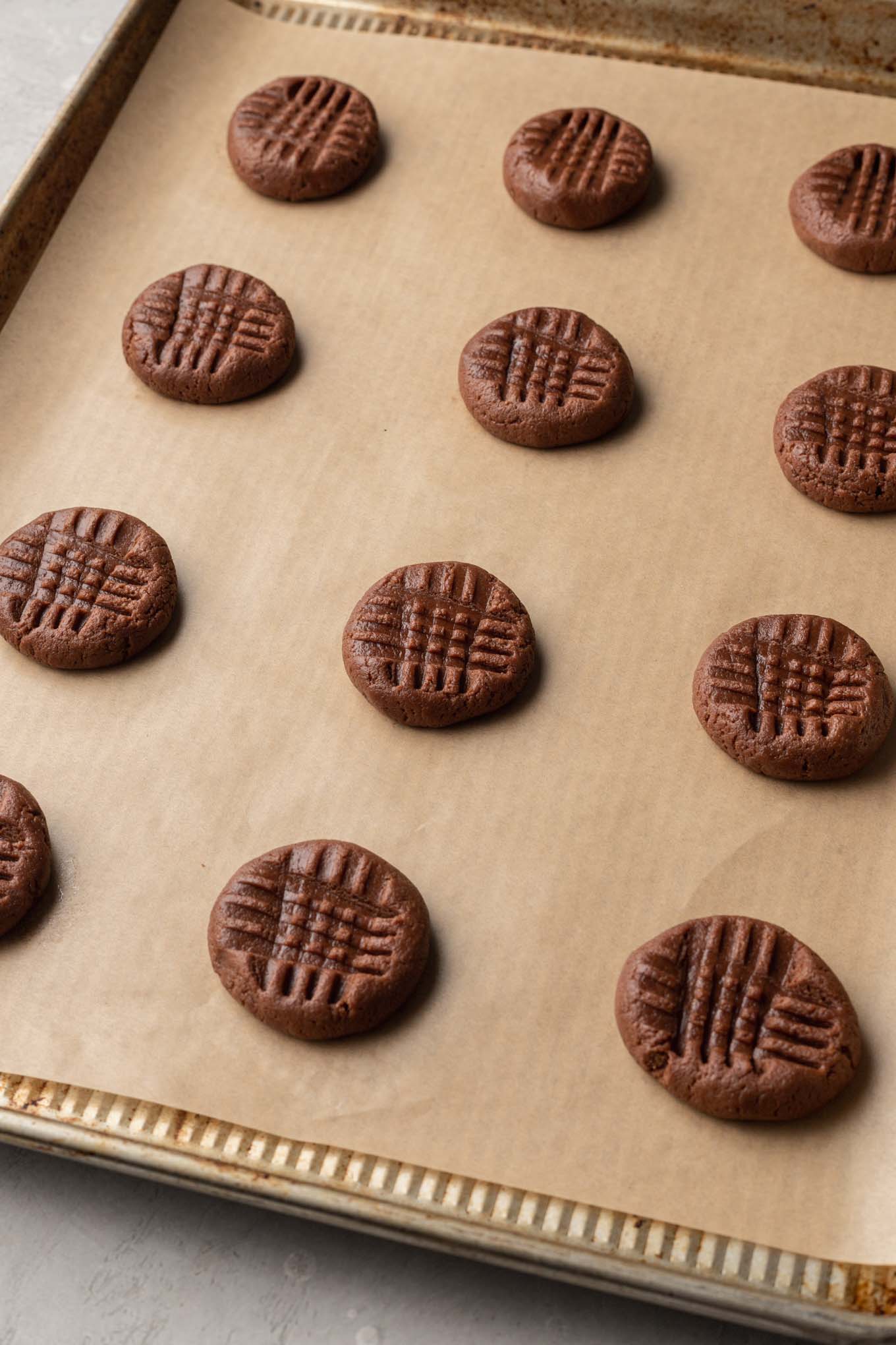 Bolas de masa para galletas de chocolate y mantequilla de maní sin hornear en una bandeja para hornear galletas. 