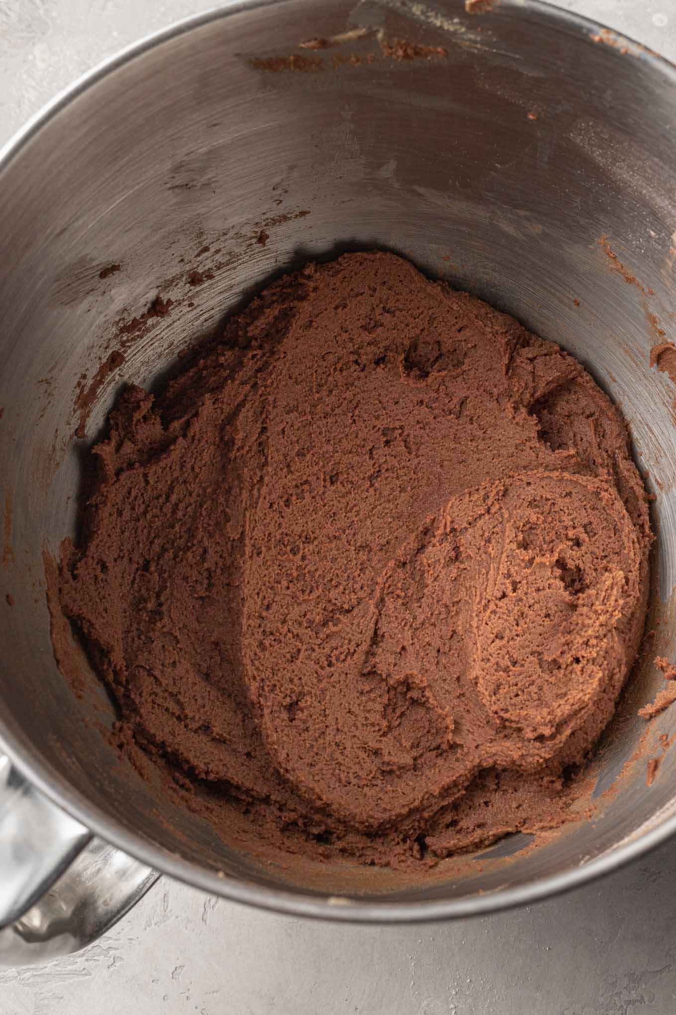 Una vista aérea de la masa de galleta de chocolate con mantequilla de maní en el tazón de una batidora de pie. 