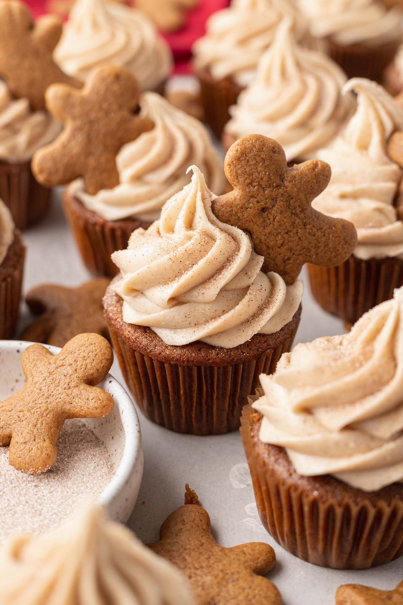 Cupcakes de pan de jengibre cubiertos con glaseado de queso crema y canela y cubiertos con una mini galleta de jengibre. 