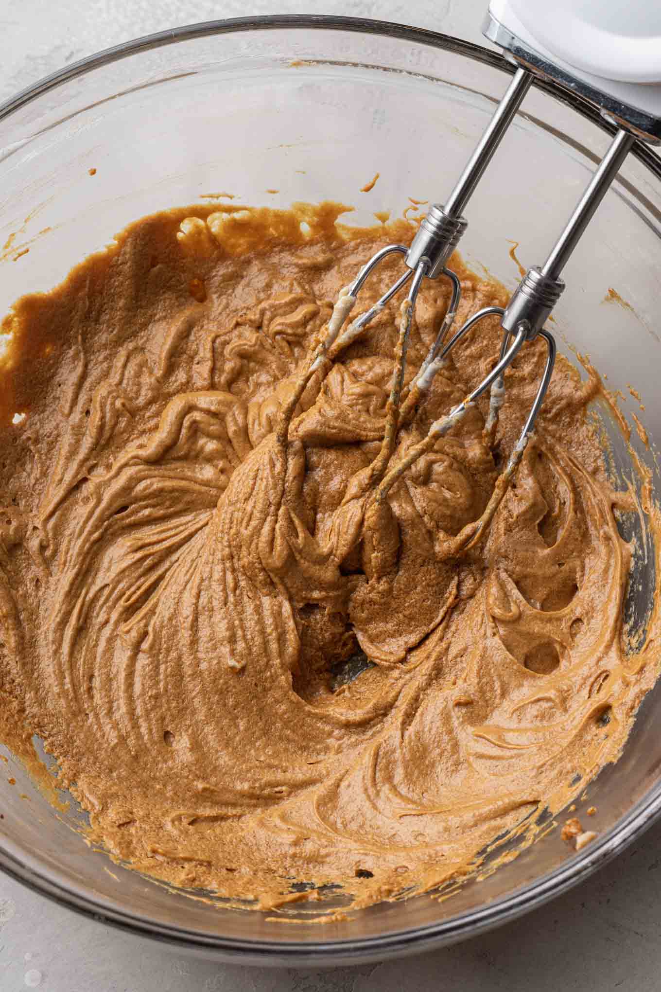 Una vista aérea de los ingredientes húmedos para pastelitos de pan de jengibre en un tazón de vidrio. 