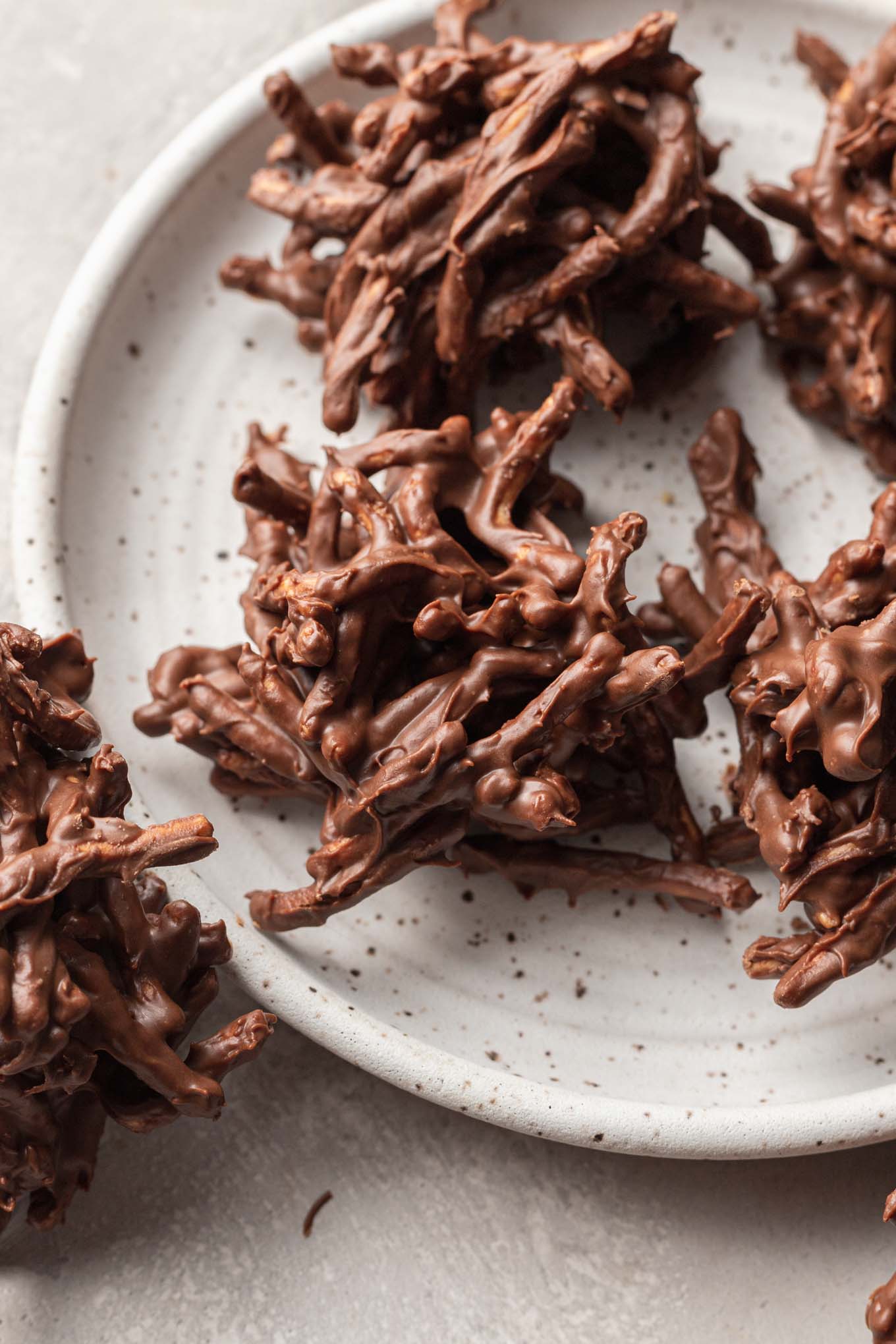 Galletas de chocolate de pajar en un plato moteado de blanco. 