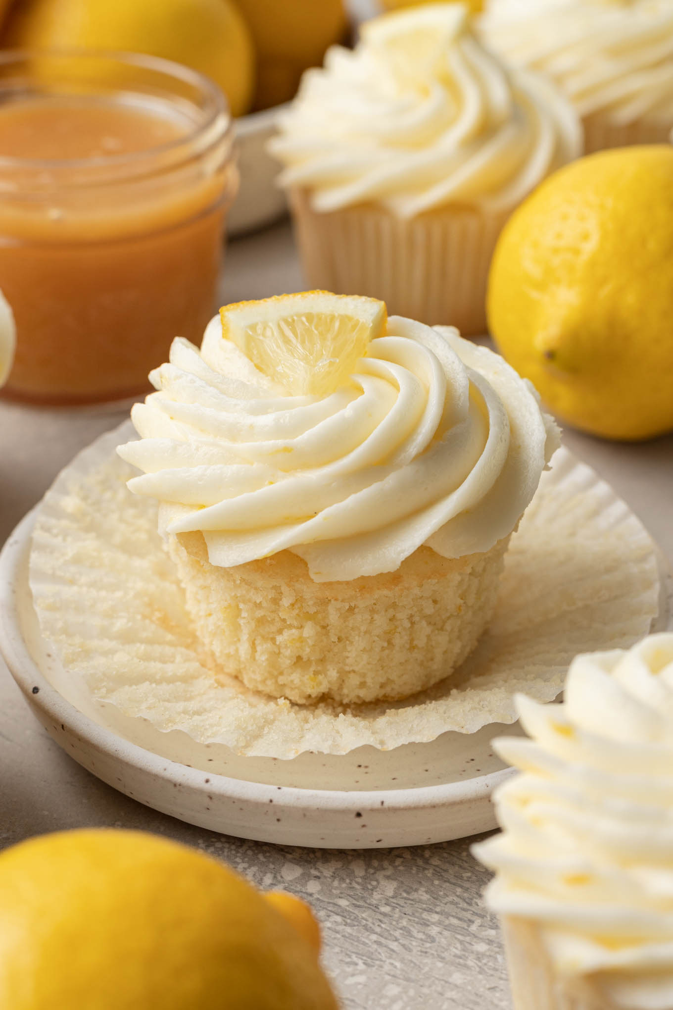 Una vista de cerca de un cupcake relleno de limón con el molde para cupcakes bajado.