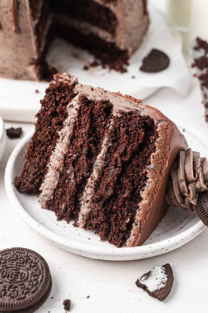 A slice of chocolate Oreo cake on a white dessert plate.