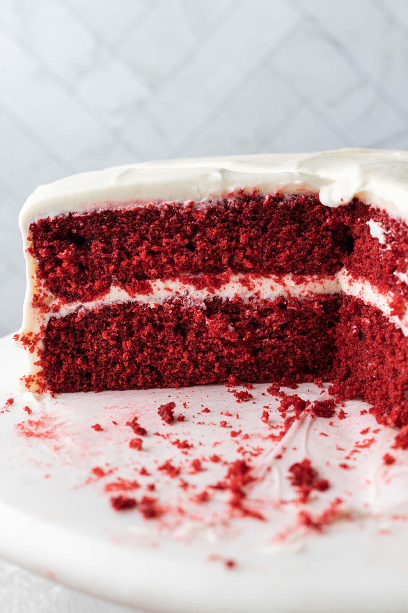 Una vista laterale di una torta di velluto rosso a fette con glassa di crema di formaggio. 