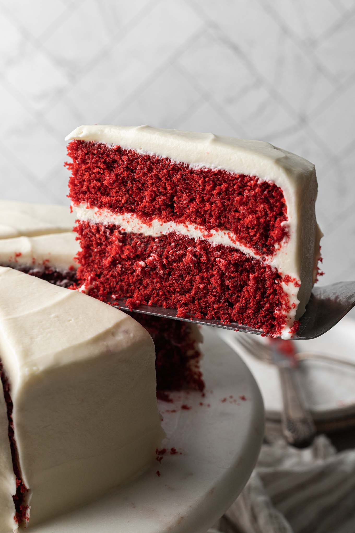 Una fetta di torta di velluto rosso servita da un'alzatina. 