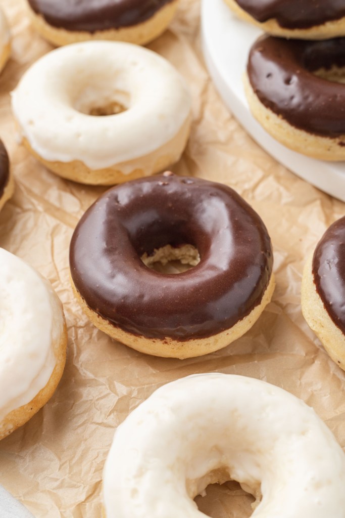 Donuts de pastel al horno con glaseado sobre papel pergamino. 