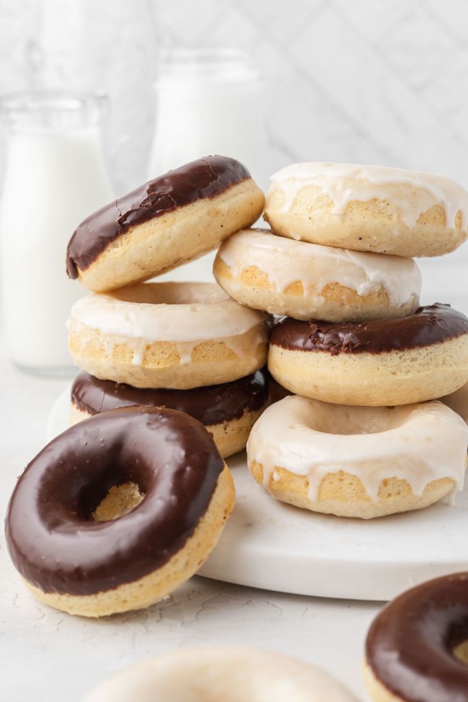 Dos pilas de donuts horneados con glaseados de vainilla y chocolate. 