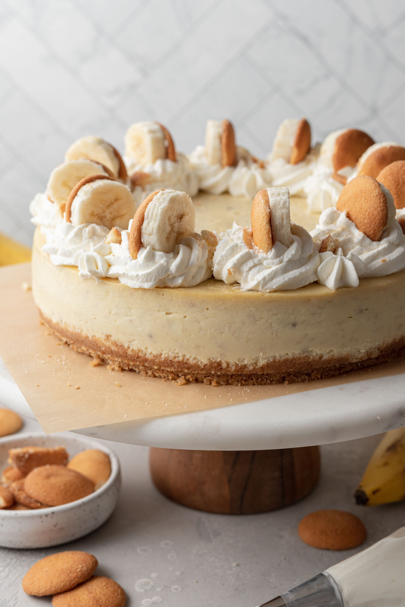 Una tarta de queso con pudín de plátano sobre un soporte para tartas. 