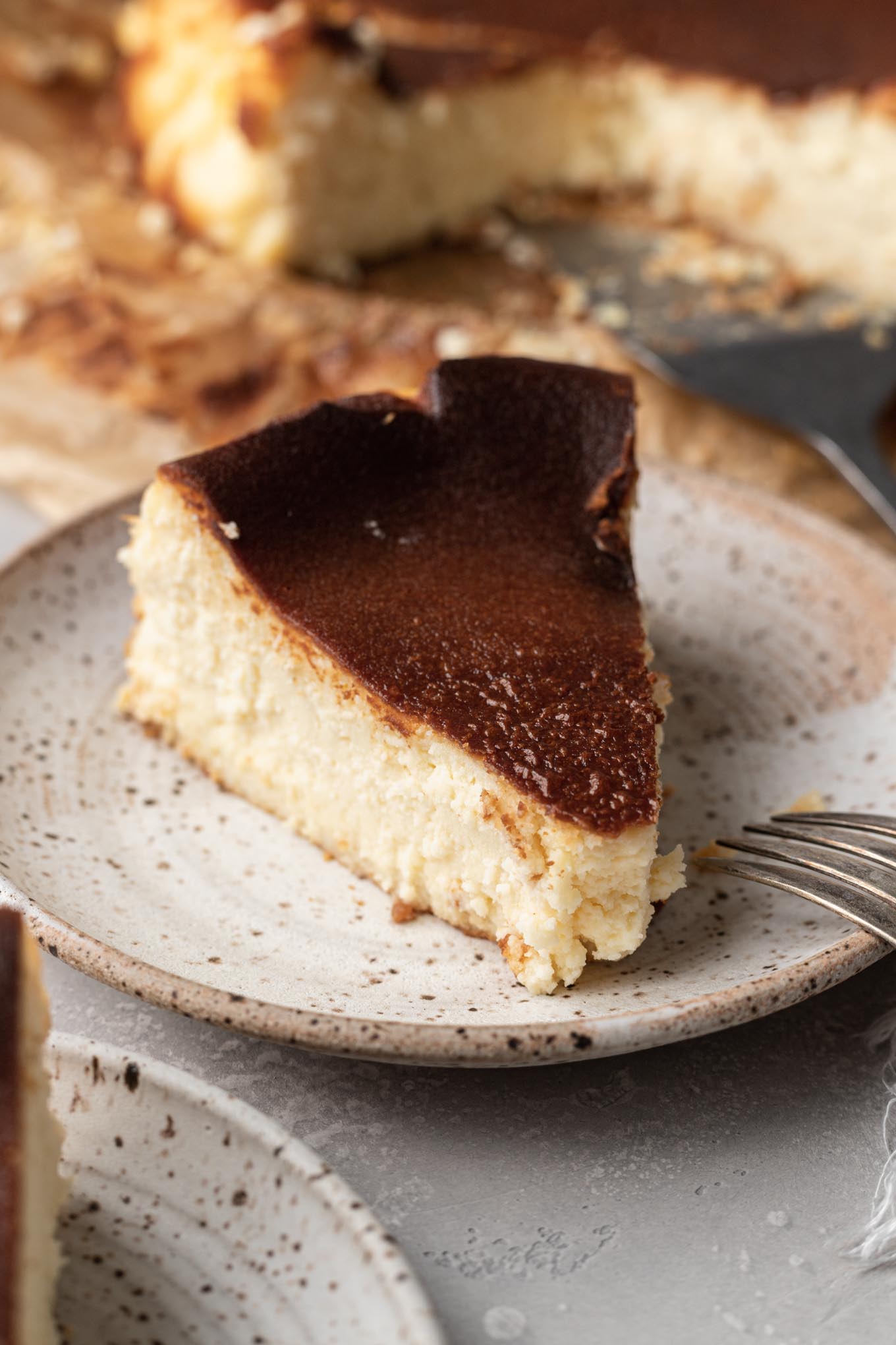 Un trozo de tarta de queso vasca quemada en un plato. 