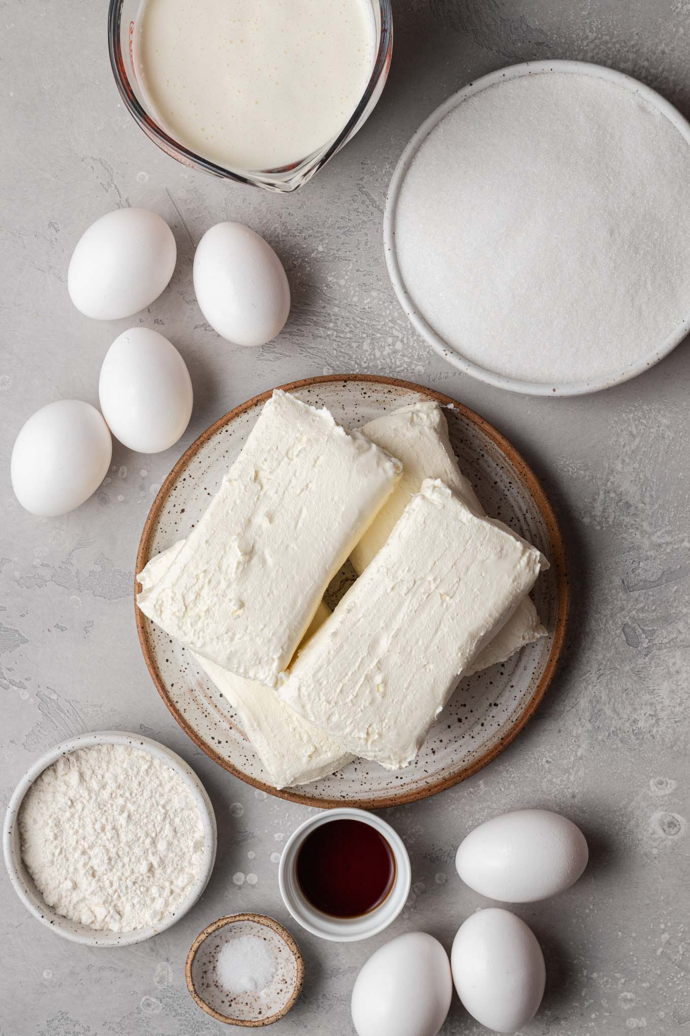 Una vista aérea de los ingredientes necesarios para hacer una tarta de queso al estilo vasco. 