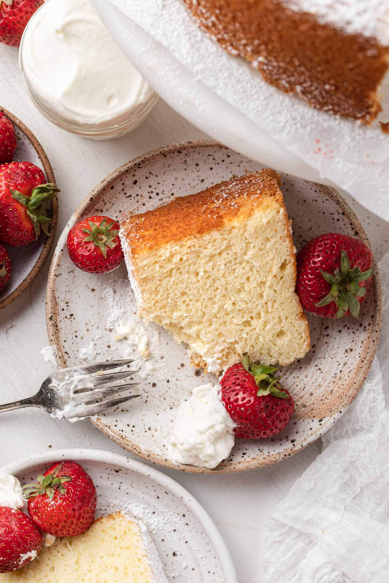 Una vista aérea de rebanadas de pastel de gasa con crema batida y frutos rojos. 