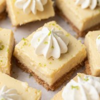 Varias barras de tarta de lima en rodajas cubiertas con crema batida.