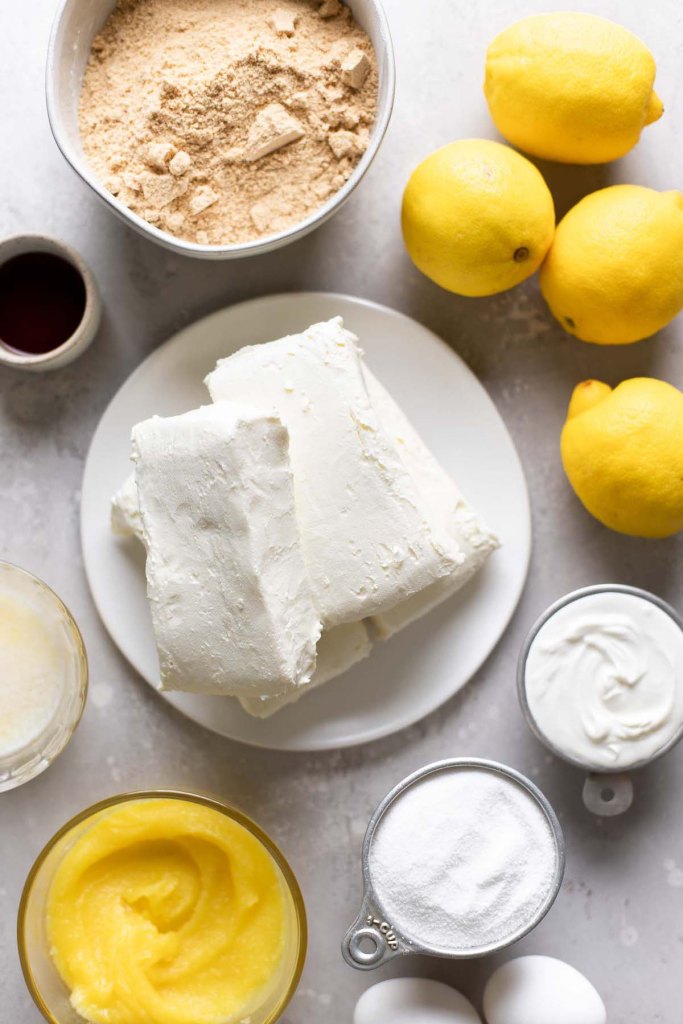 Una vista aérea de los ingredientes necesarios para hacer una tarta de queso con cuajada de limón. 