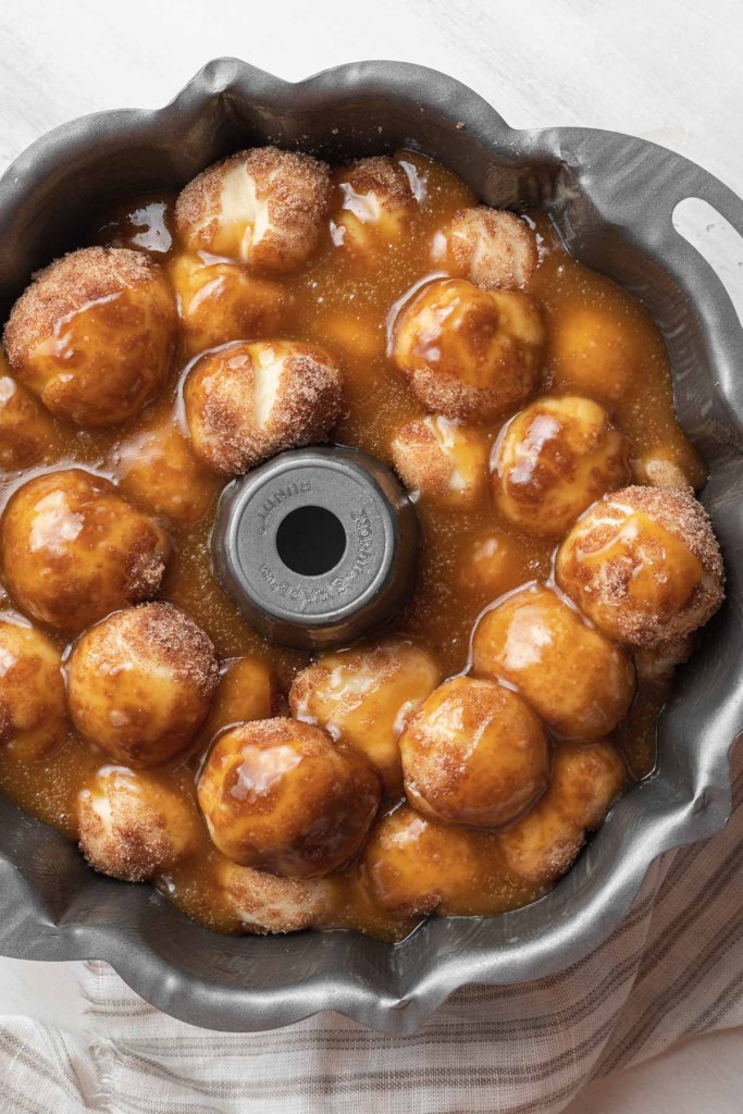 An overhead view of an assembled but unbaked pan of homemade monkey bread. 