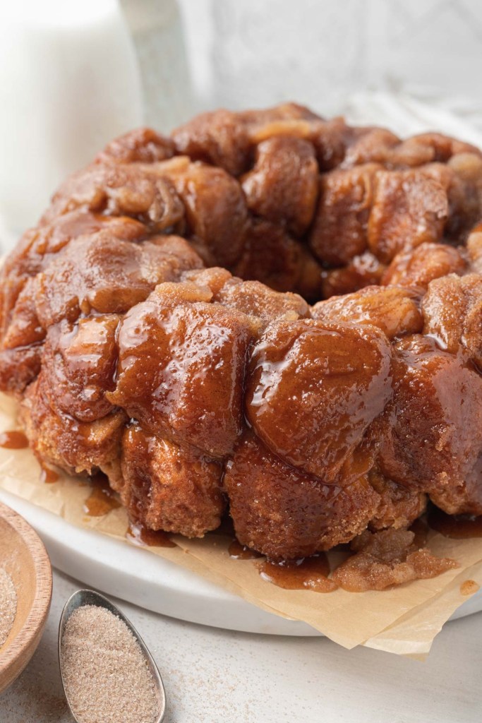 Homemade monkey bread with caramel sauce on a round platter. 