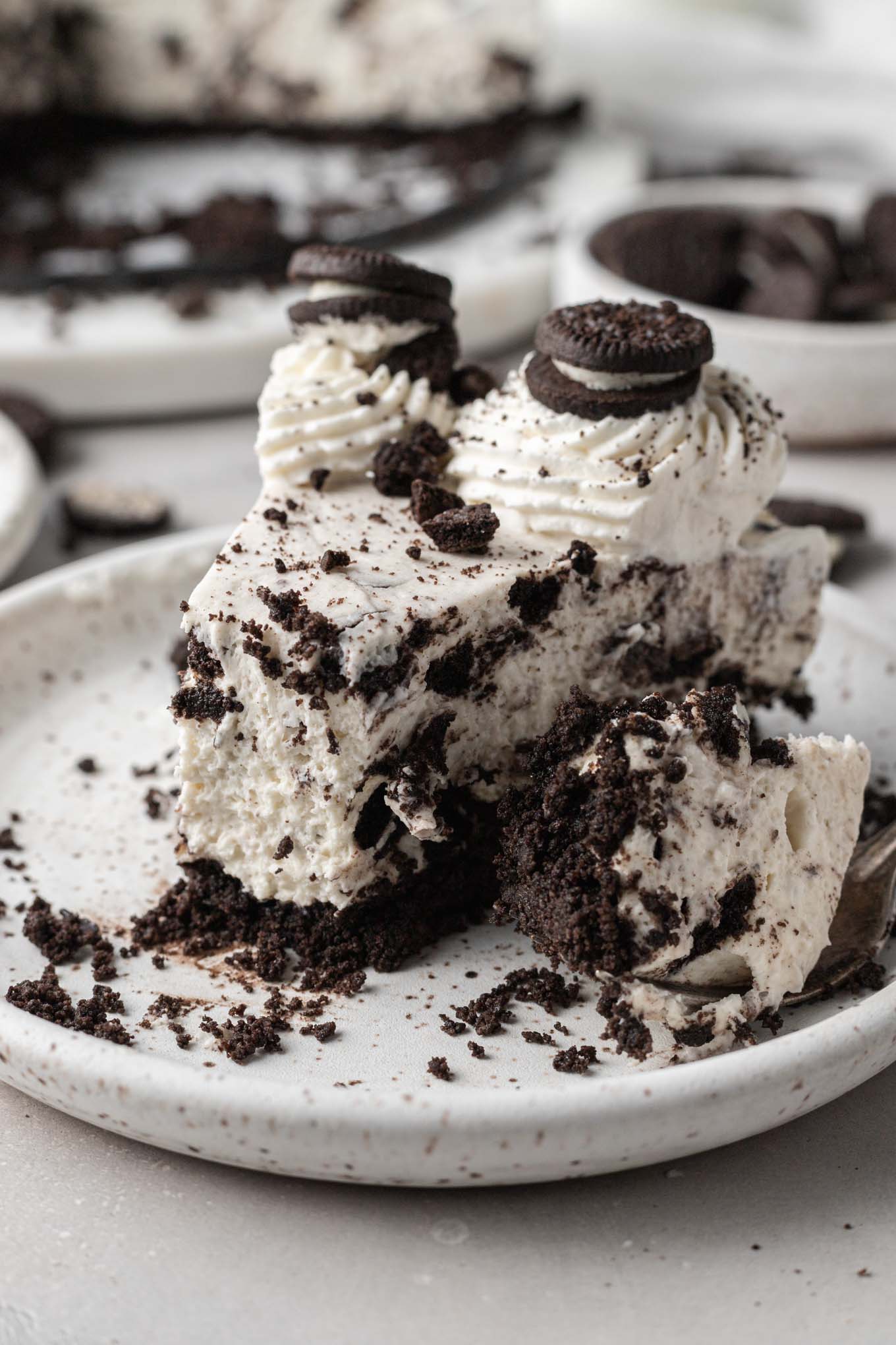 Una rebanada de tarta de queso Oreo sin hornear, a la que le falta un bocado. 