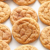 Varias galletas de calabaza alineadas sobre un trozo de papel pergamino.