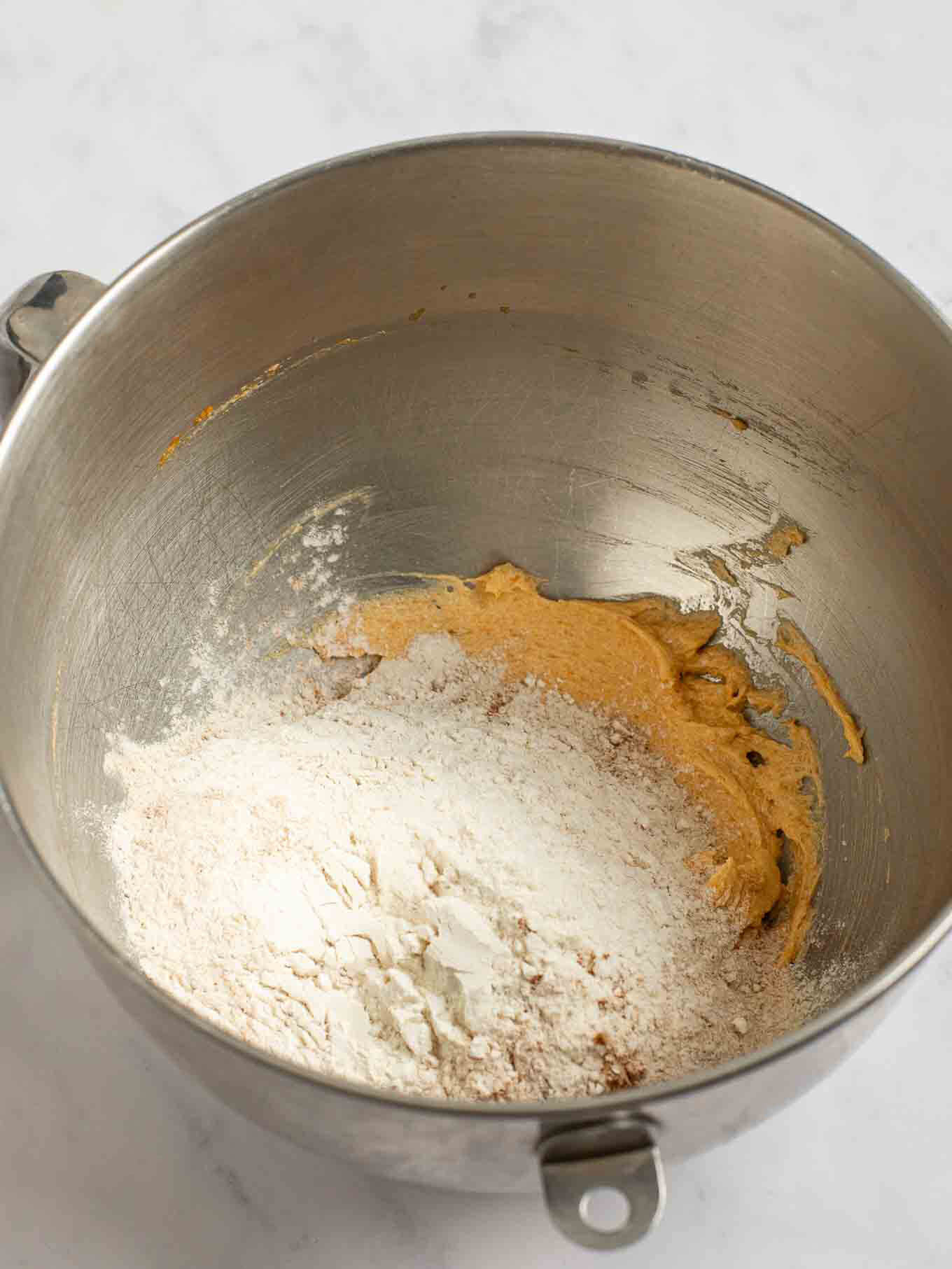 Los ingredientes secos se agregaron encima de los ingredientes húmedos en el tazón de una batidora de pie.