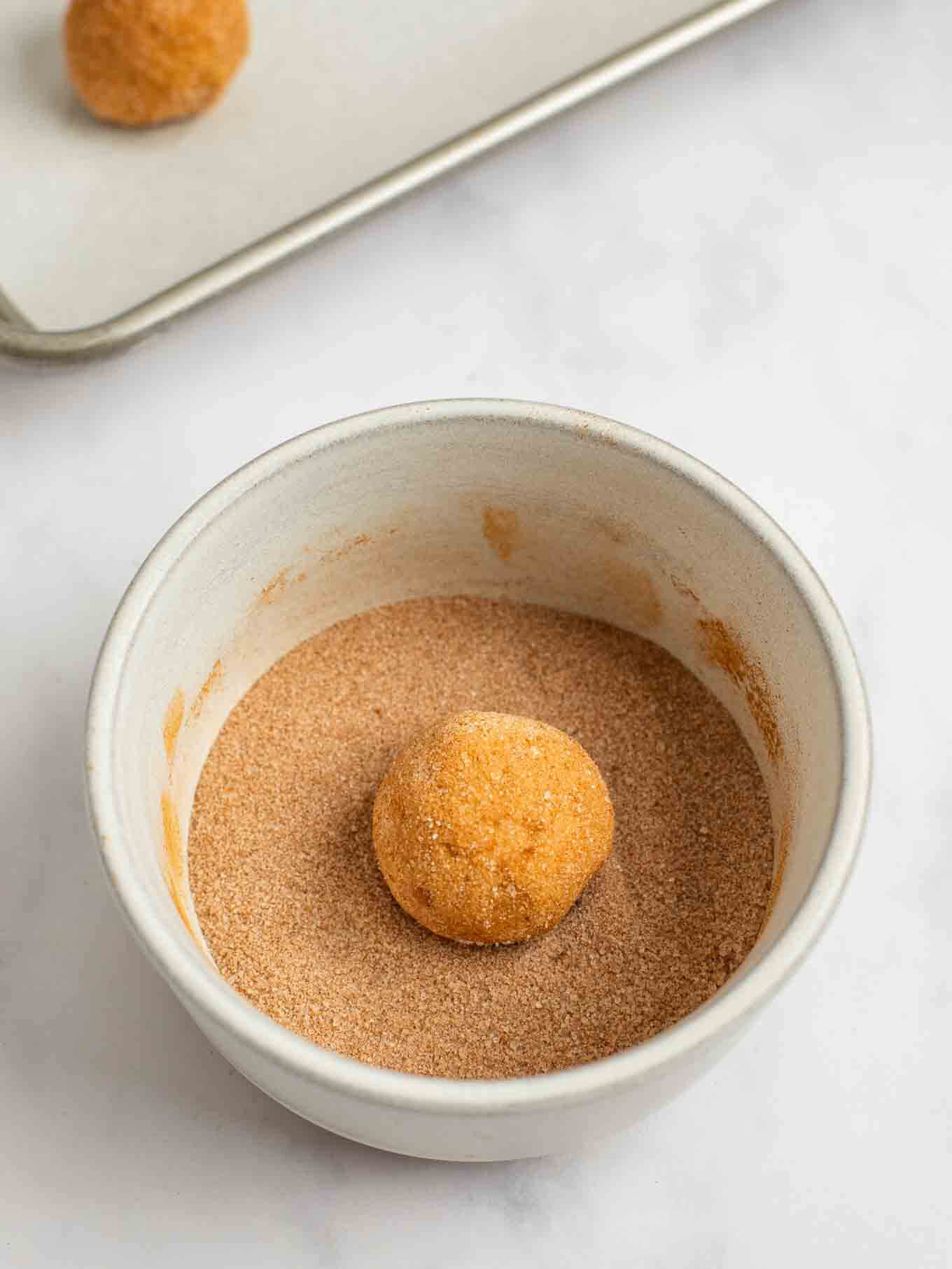 Una bola de masa para galletas enrollada en canela y azúcar.