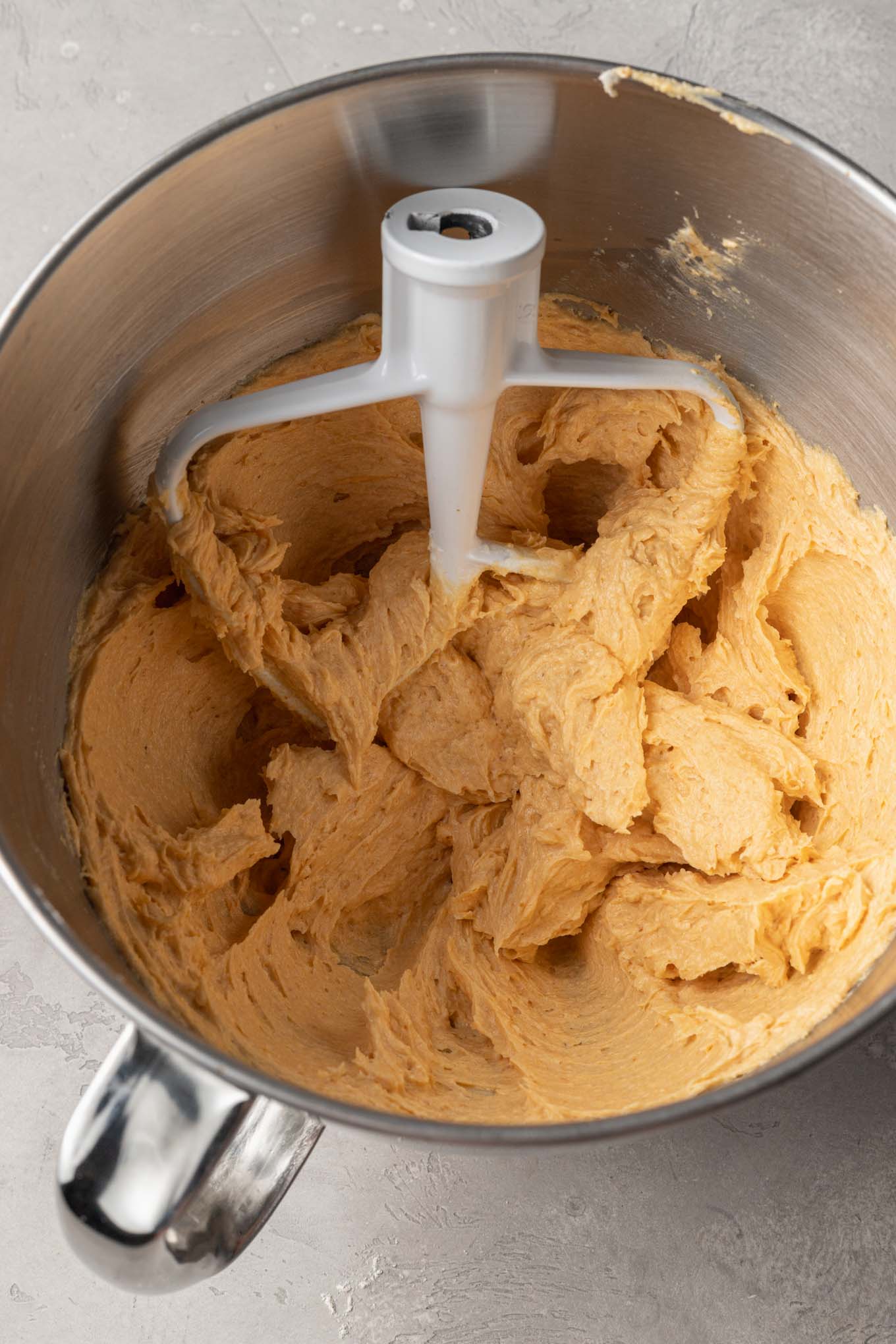 Una vista aérea de los ingredientes húmedos para las galletas de azúcar y calabaza en una batidora de pie. 