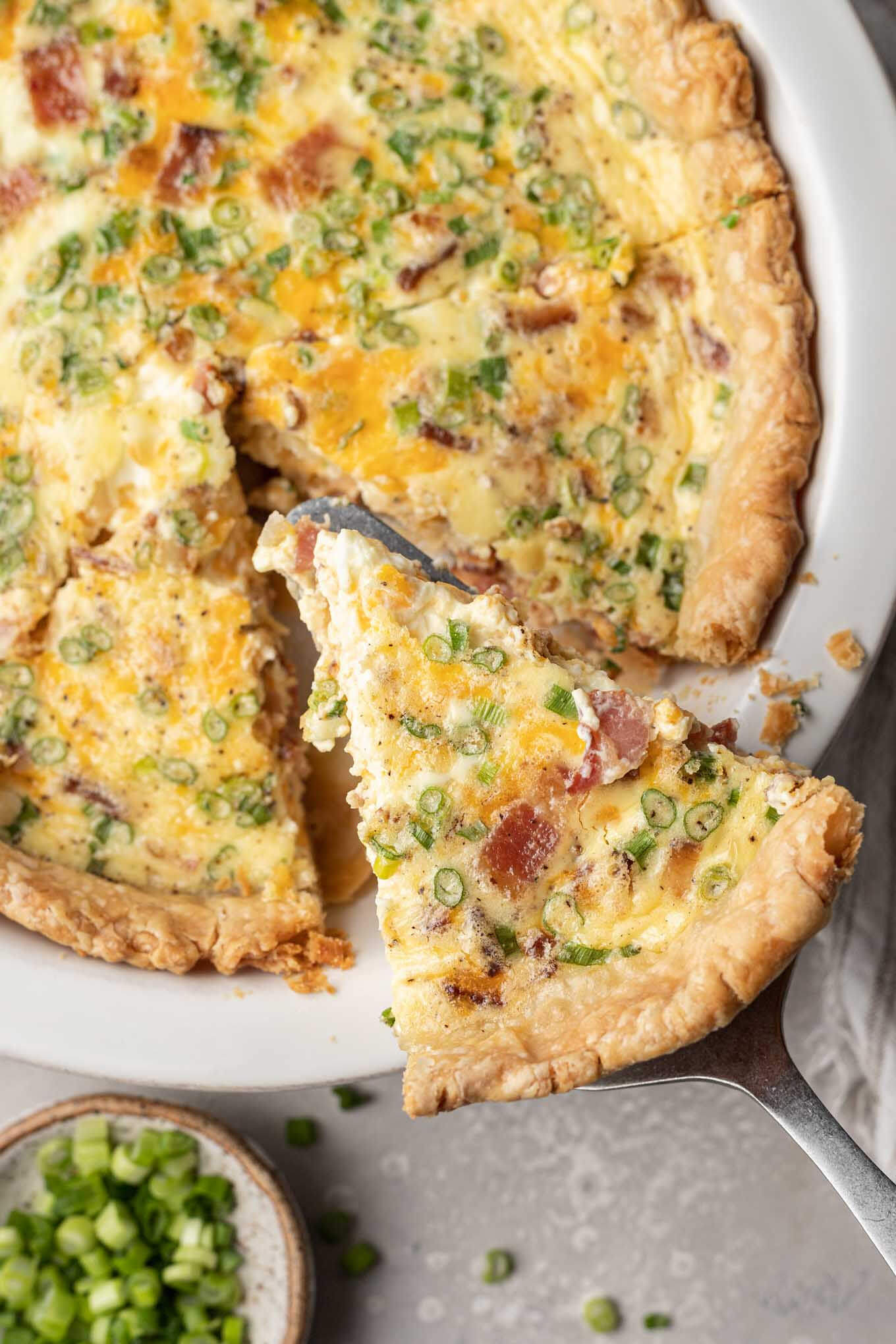 Una vista aérea de una rebanada de quiche que se retira de un molde para pastel. 