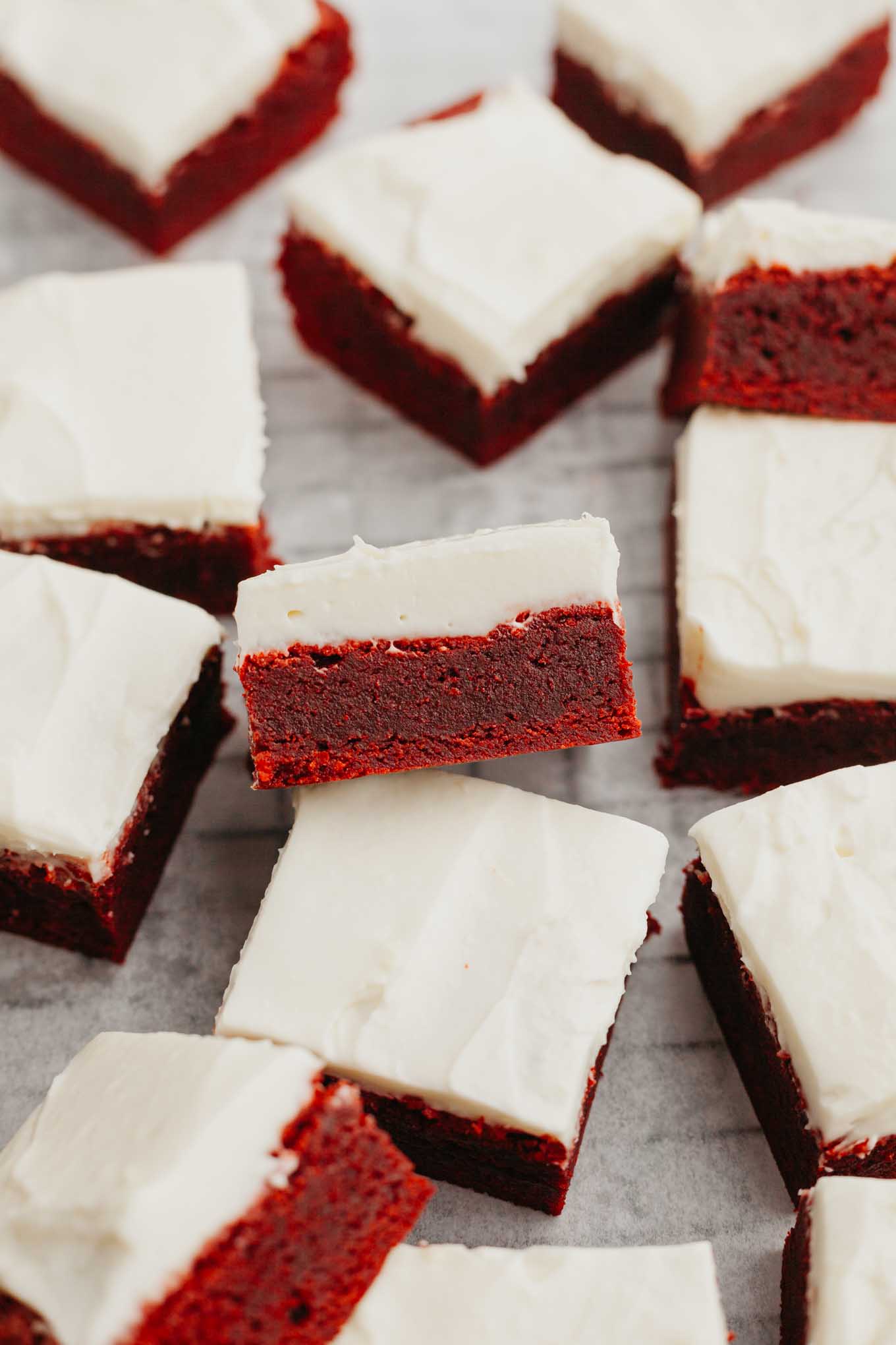 Brownies de terciopelo rojo glaseados cortados en rodajas y dispuestos sobre una rejilla. 