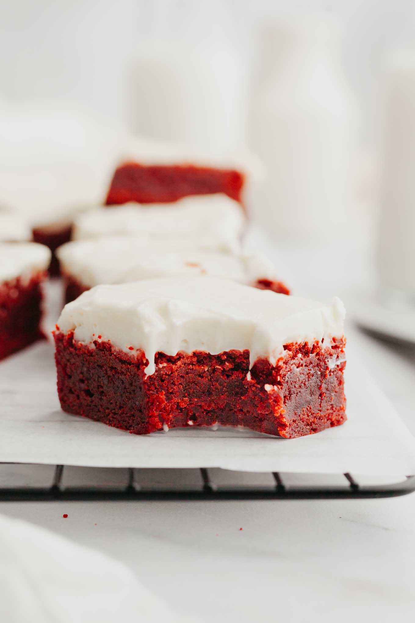 Una vista lateral de un brownie de terciopelo rojo al que le falta un bocado. 