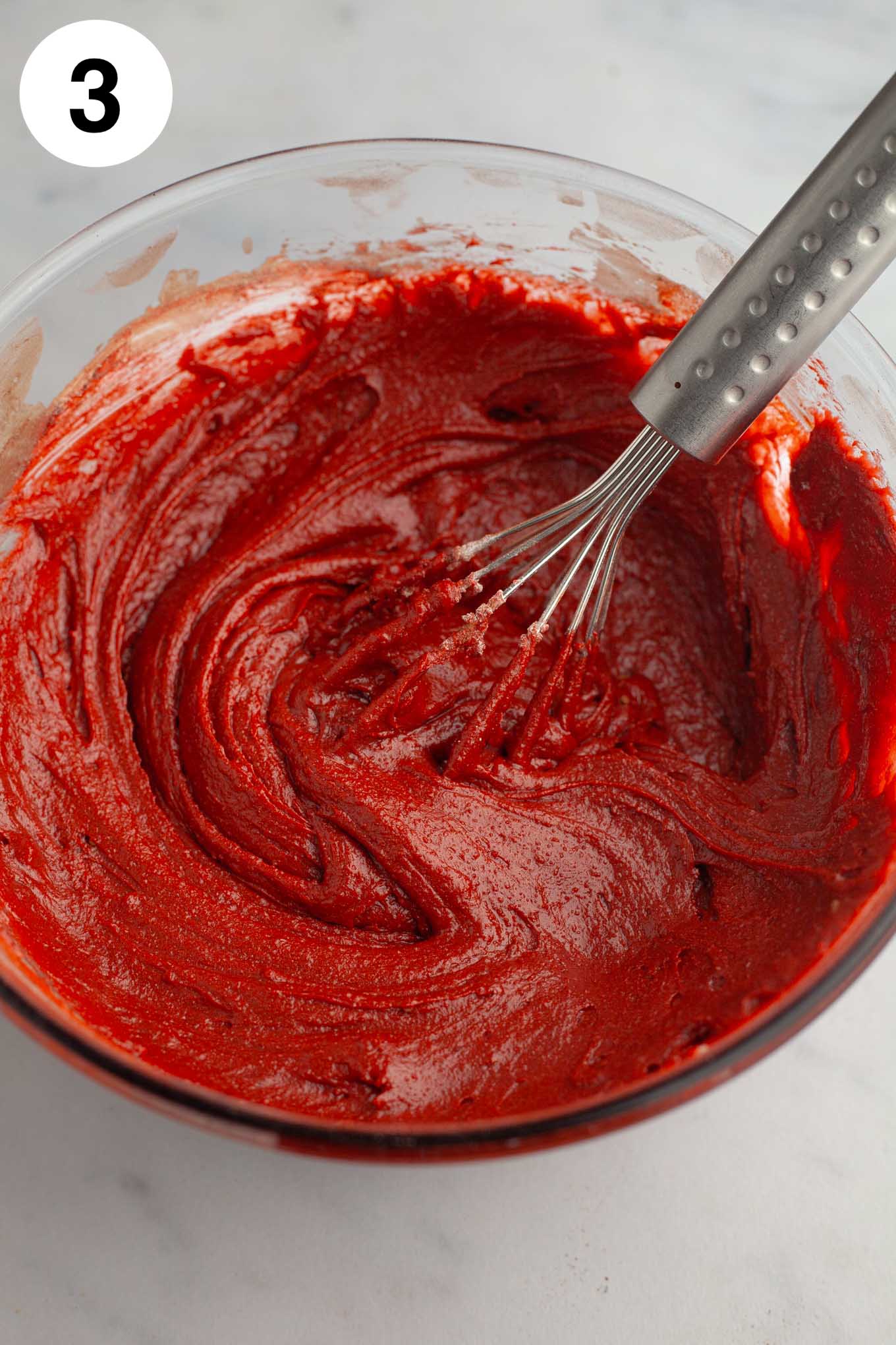 Masa de brownie de terciopelo rojo en un tazón de vidrio.