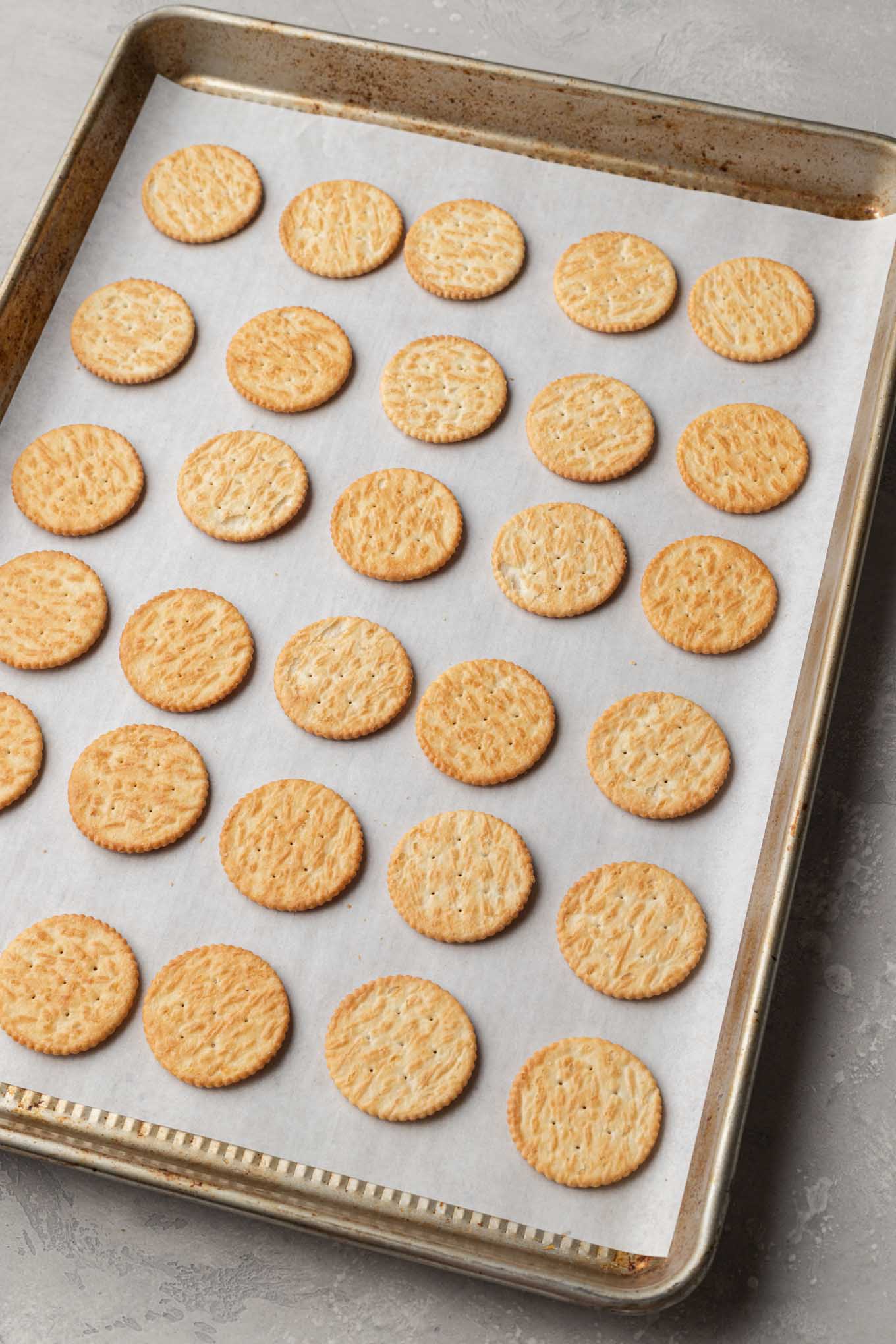 Una vista aérea de las galletas Ritz alineadas en una bandeja para hornear. 