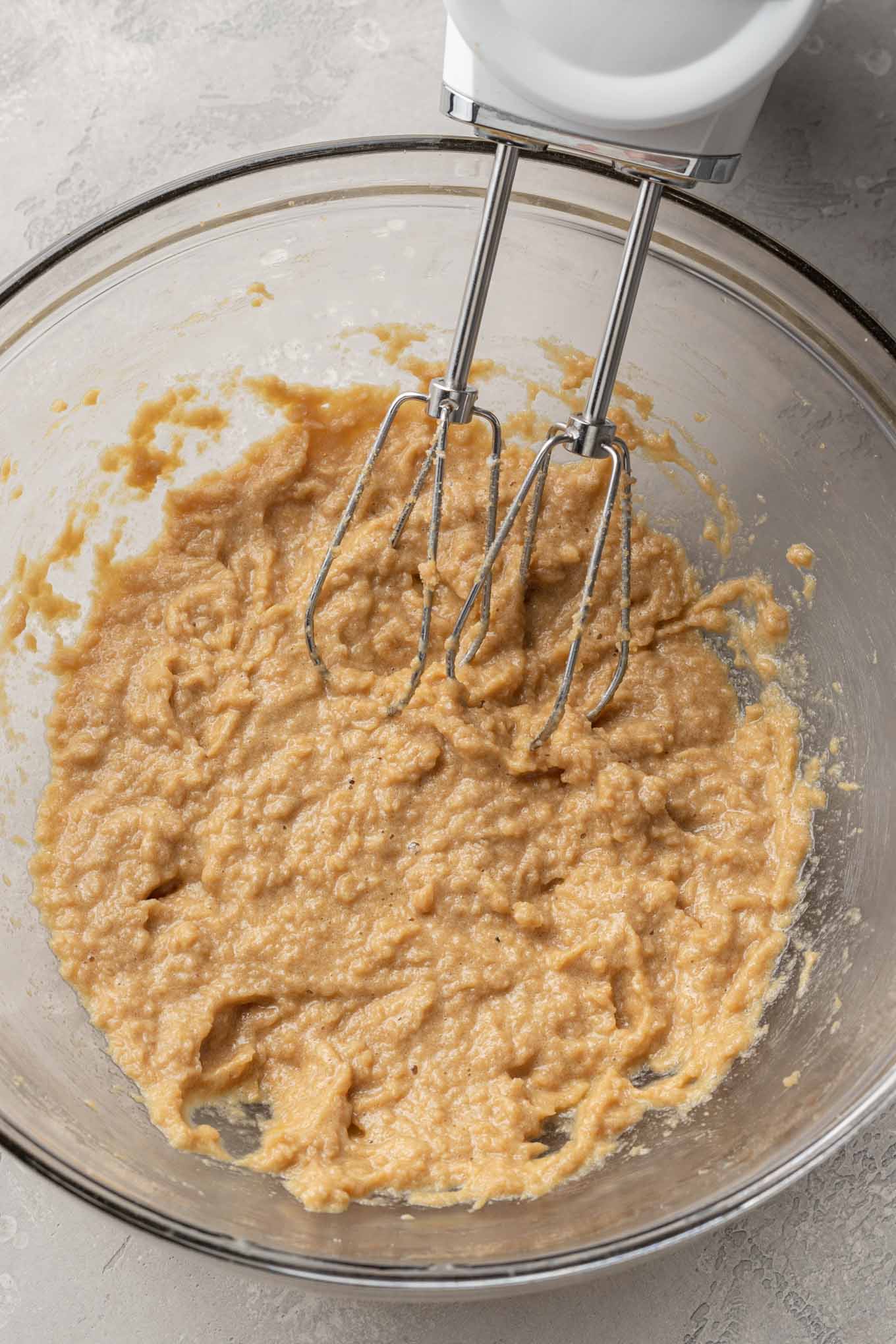 Una vista aérea de los ingredientes húmedos para las barras de s'mores en un tazón de vidrio. 