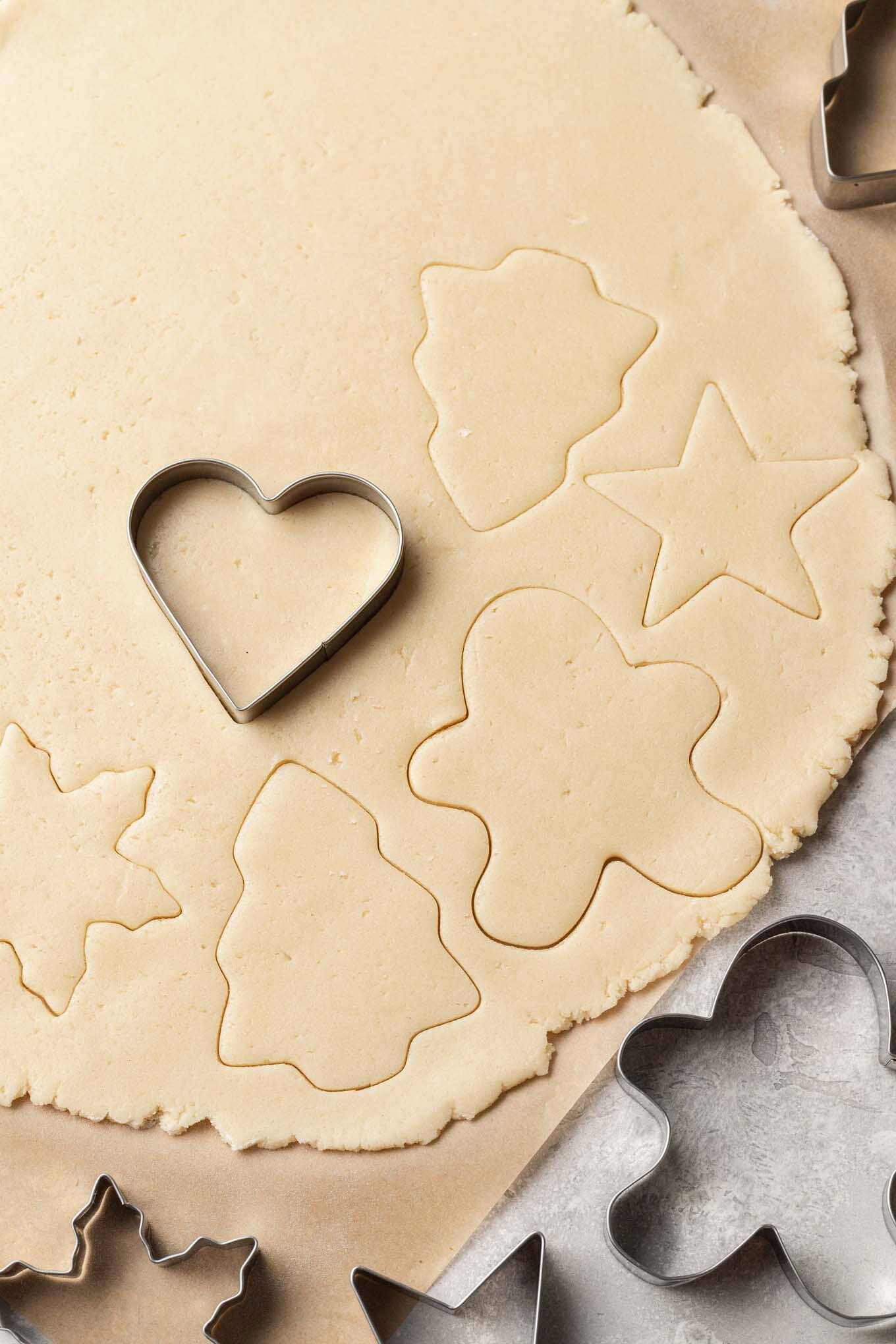 Una vista aérea de la masa de galletas de azúcar cortada en formas festivas. 