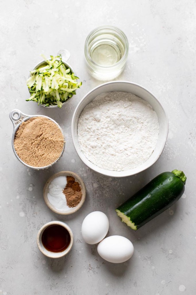 Una vista aérea de los ingredientes necesarios para hacer muffins de calabacín caseros. 